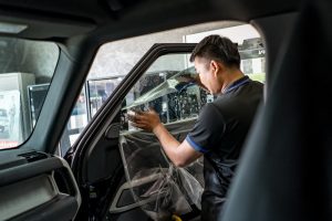 worker applying tints inside Performance Auto Group LLC