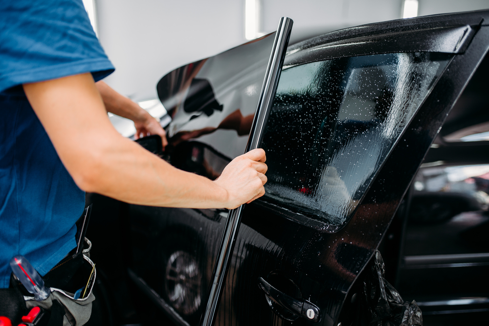 car tint worker applying tints Performance Auto Group LLC